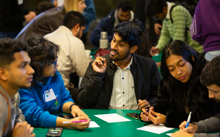 UCD alumni engaged in a discussion around a table.